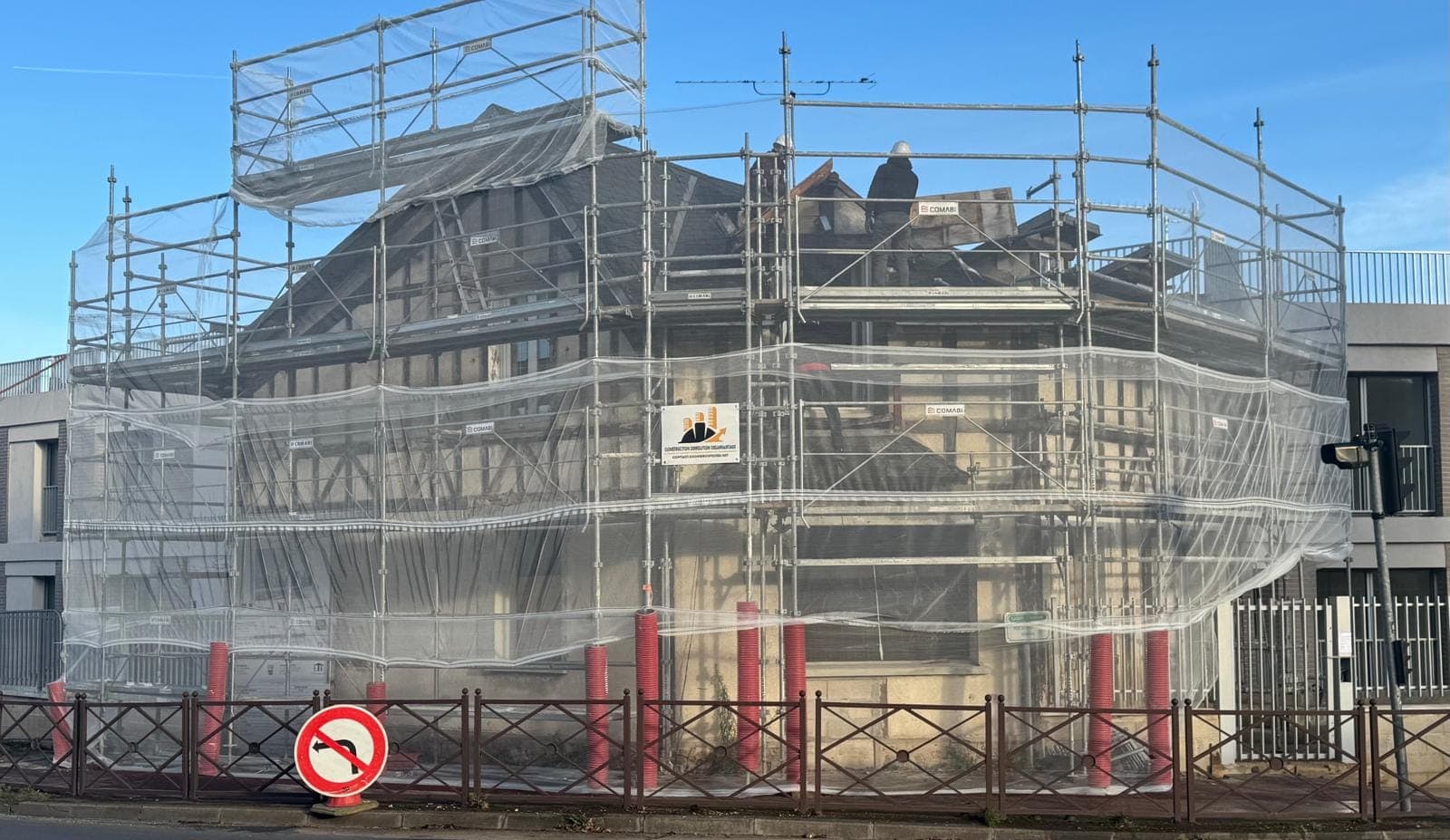 Bâtiment en restructuration sous échafaudage, panneau CDD sur la façade
